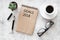 Words Goals for 2018 writting in notebook near glasses and cup of coffee on grey stone background top view mockup