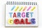 Words goals target on notebook over white background