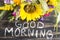 Words Good Morning with Summer Flowers on a Rustic Wooden Background