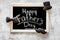 Words happy Father`s day written on blackboard. Black tie, mustache and hat cookies. Grey stone background top view