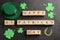 Words Happy St. Patrick`s day, hat and festive decor on black slate background, flat lay