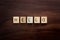 Words Hello Spelled out in Wooden Letter Blocks on Dark Walnut Wood Background