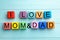 Words I LOVE MOM and DAD made from alphabet cubes on blue wooden table