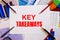 The words KEY TAKEAWAYS is written on a white background near colored graphs, pens and pencils. Business concept