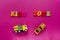 Words `kids zone` with toy cars on pink background.