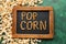 Words made of kernels on chalkboard and delicious popcorn on green table