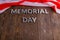 the words memorial day laid with silver metal letters on wooden board surface with crumpled usa flag below