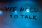 The words we need to talk handwritten by finger on night foggy wet window glass