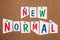 The words new normal are standing in colorful letters on pinned paper, changing world, different points of view