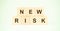 Words new risk made with small wooden blocks on light green