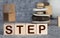 The words Next Step on small wooden dices on a table, close up shot, view from above