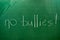 The words NO BULLIES written on the green school board