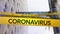 Words Quarantine, Warning and coronavirus written on yellow tape over a Wall Street street sign in t