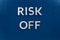 The words risk off laid with silver metal letters on classic blue surface for stock market background
