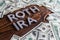 Words ROTH IRA laid on wooden surface by metal letters with us dollar banknotes