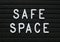 The words Safe Space in white plastic letters on a black letter board