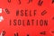 Words self isolation and hashtag on red background