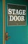 The words Stage Door written on green metal entryway to building
