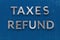 The words taxes refund laid on classic blue board with thick silver metal aphabet haracters