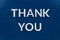 The words thank you laid with aluminium white metal letters on painted flat blue background - directly above in flat lay