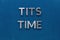 The words tits time laid with silver metal letters on classic blue board in flat lay with central composition