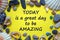 Words `today is a great day to be amazing` on a beautiful yellow background. Sea stones and seashells. Inspirational and