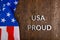 words USA proud laid with silver metal letters on brown wooden surface with flag of United States of America