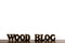 The words WOOD BLOG are made of wooden letters on a background of dark brown wood.Copy space on top for an inscription or logo.. S