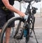 Work activity. One senior people with dark sportwear washes his bicycle at the service station. Outdoor. High pressure pomp