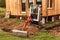 Work on the construction site of an ecological house. The excavator adjusts the terrain. A small digger in the garden.