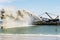 Work dredger dredging with sand washing on beaches. Special dredging hose for sand to create new land. Sand washing on sea
