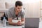 Work from home and training. Young man doing plank, near laptop and water