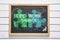 Work-life balance. Chalkboard with drawing of connected puzzle pieces on wooden background, top view