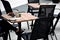 At a work meeting, terrace of a cafe on the sidewalk in the administrative zone. black mesh chairs and square wooden tables. a pap