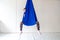 Work out on a hammock with a great yoga coach in the studio. Fly yoga. A girl sits in a blue anti-gravity yoga hammock