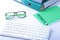 Work place table with folders file on it and modern laptop, pen, glasses and textbook lying near on a white background.