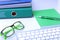 Work place table with folders file on it and modern laptop, pen, glasses and textbook lying near on a white background.