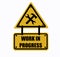 Work in progress sign with wrench and hammer in a yellow triangle Text below.