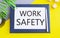 Work Safety message text written on white paper above Notebook.Conceptual photo policies and procedures in place to ensure safety