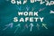 WORK SAFETY. White letters of the wooden alphabet. Colored pieces of chalk on a green chalk board