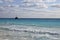 Work ship in bright blue sea and sky with clouds