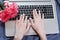 Work space at home, keyboard top view, female hand close up, notebook, work space on bed top view, flowers, colour background