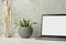 Work table with laptop with white clean screen, flower and wooden drawing figure