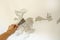 Work tool, putty knife in hand on a white wall background, work plasterer, cleaning the wall of old paint