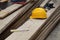 work tools in the yard: the helmet, the meter, the shovel and the gloves resting on the wooden boards