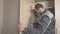 Worker adjusts the doors in the cabinet and installs the hardware, accessories