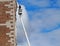 A worker, on the aerial platform of the cherry picker, maintains the facade of the building. Blue sky with fluffy clouds on backgr