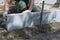 A worker aligns a road curb into cement with his hands.