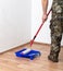 A worker applies wallpaper paste to the walls in a room with a roller