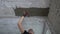 Worker applying putty between slabs on ceiling